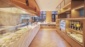 Un bufé de desayuno moderno con una variedad de alimentos y bebidas, un respaldo de azulejos y un piso de madera.