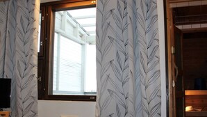 Habitación triple, sauna | Escritorio, cortinas blackout y tabla de planchar con plancha