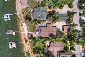 Vista aérea de una zona residencial con casas, un muelle y una piscina.