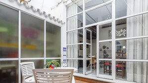 A sunlit patio with a table and chairs, large windows, and a tiled floor. - DUPLEX DREAMS OF SEVILLE A QUALITIES PARKING (Sevilla)