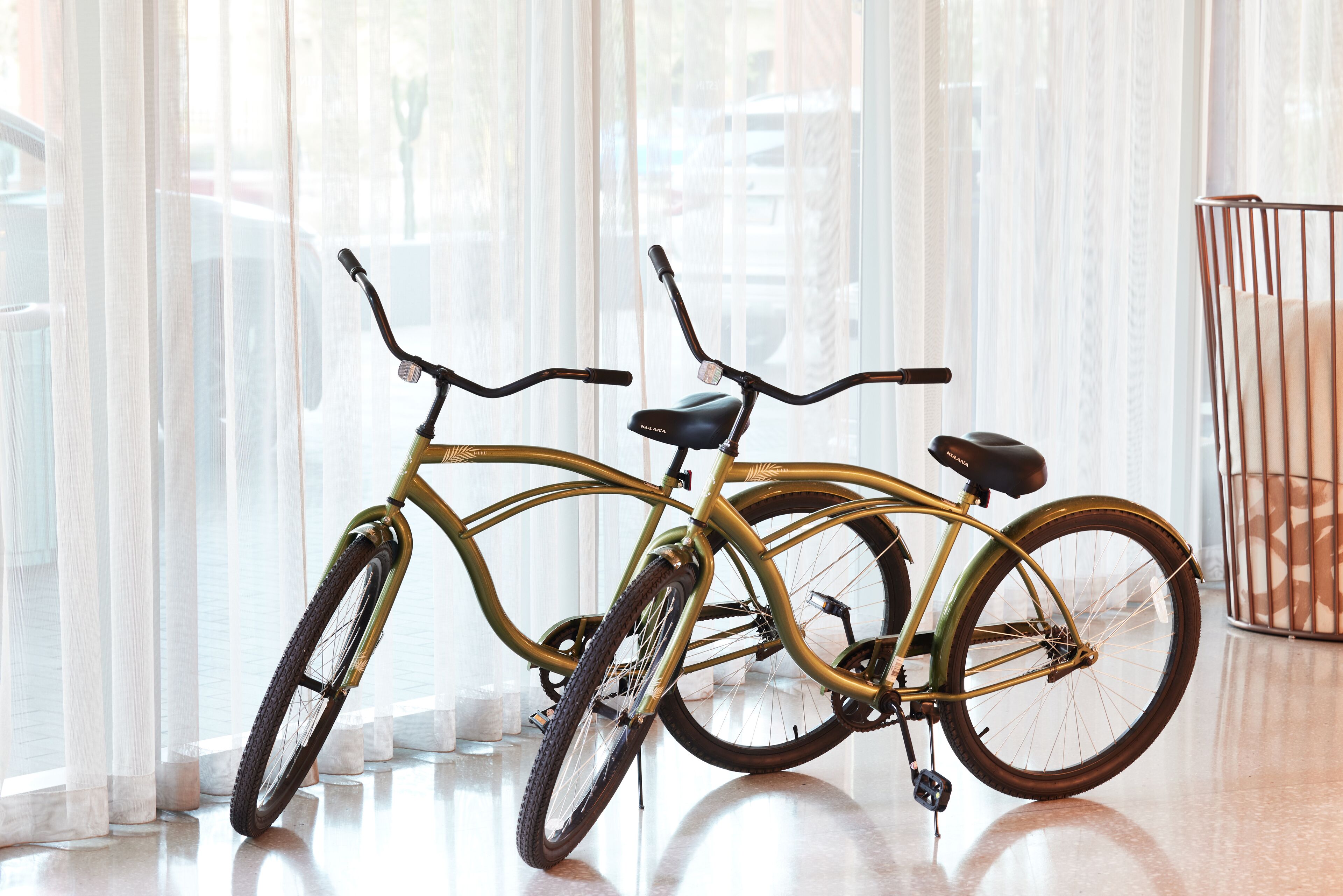 Una bicicleta en una habitación con ventanas amplias y una reja metálica.