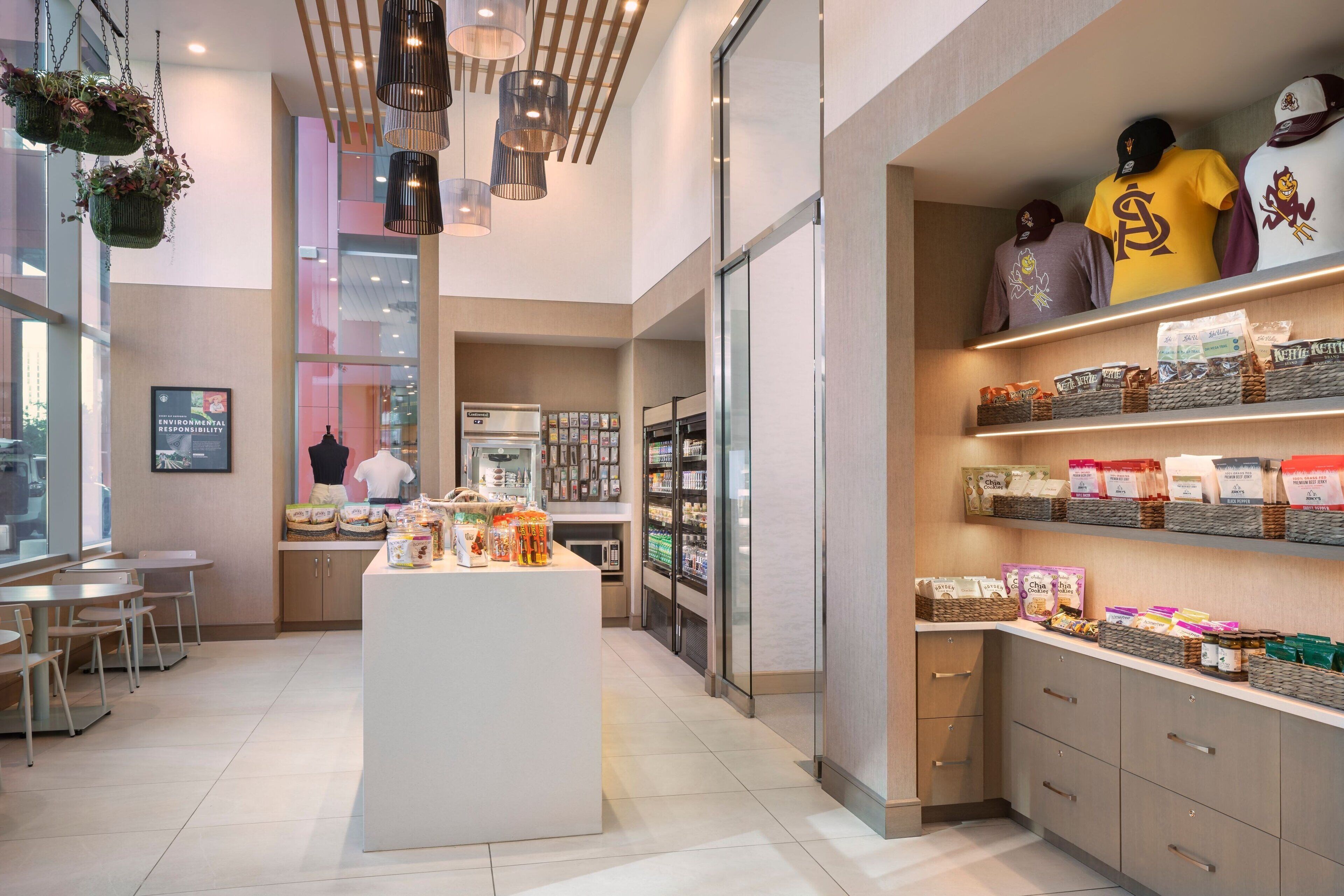 Un café moderne doté d’un îlot central, d’un espace salon et d’étagères où sont exposés des produits emballés.