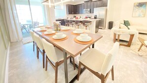 Un espace repas moderne avec une table en bois, dressée pour six personnes, entourée de chaises.