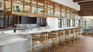 Une cuisine moderne avec un coin bar, un plafond en bois et de grandes fenêtres.