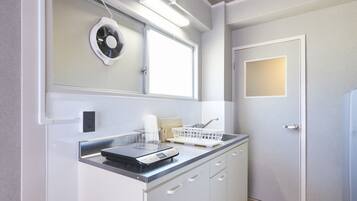 A modern kitchen with white cabinetry, a built-in oven, and a window above the sink.