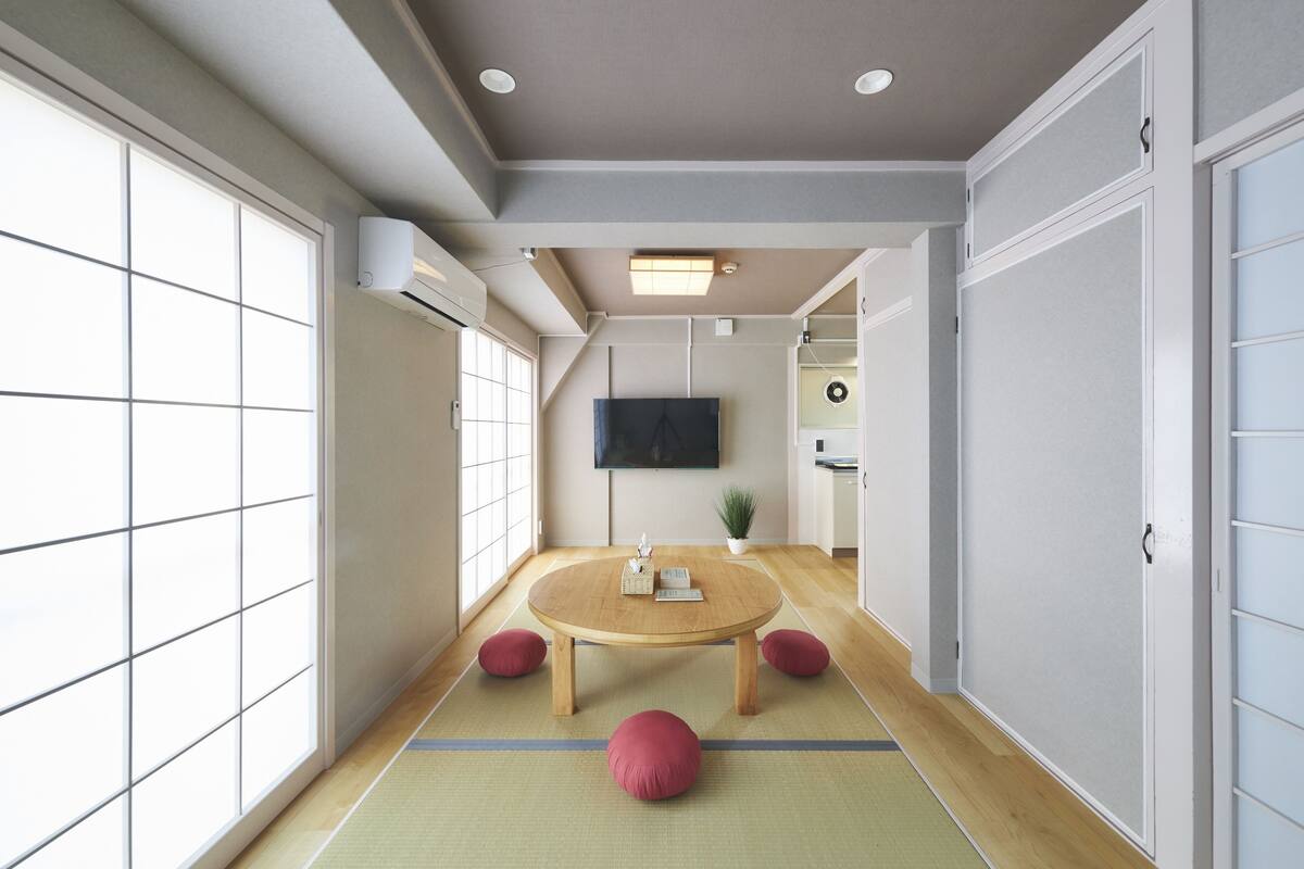 A traditional Japanese room with tatami flooring, a tatami mat table, and shoji screens.