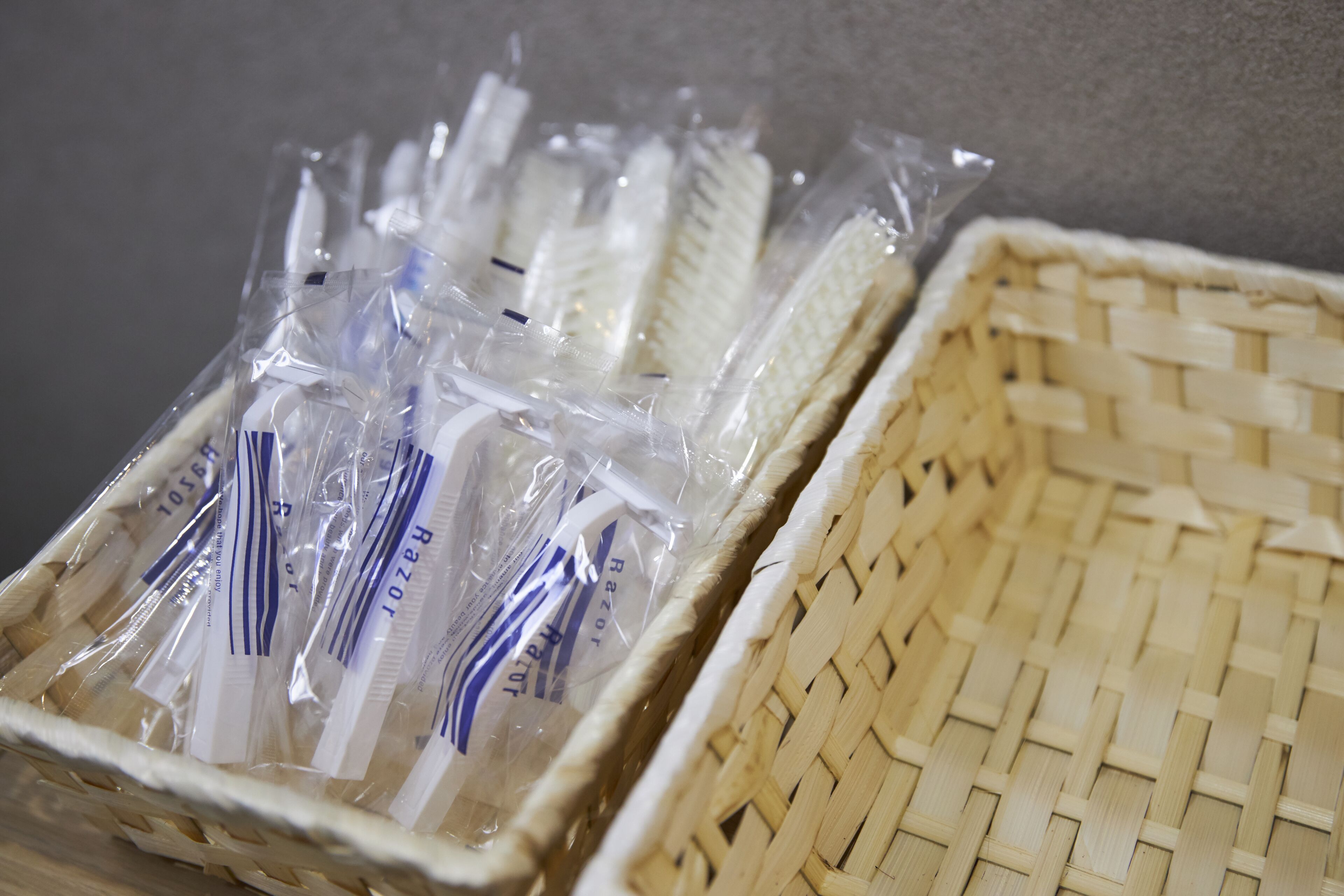 Una cesta de mimbre con varios paquetes de plástico y etiquetas blancas y azules.