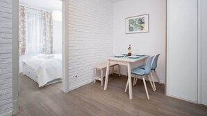 Una camera da letto con un letto, un tavolino con sedie e un quadro appeso al muro.
