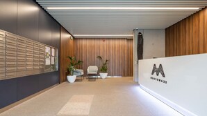 A modern reception area with a wooden wall, a reception desk, and a row of lockers.