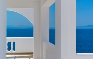 A white interior with a view of the sea and distant mountains.