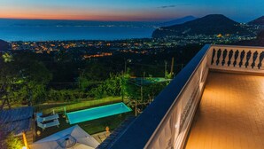 Eine Dachterrasse mit Pool und Blick auf eine Stadtlandschaft, sowie ein Berg im Hintergrund.