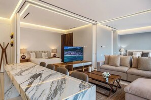 A modern living room with a marble coffee table, a television, a sofa, and a dining area.