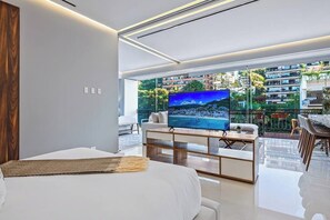Une chambre d’hôtel moderne dotée d’un grand lit, d’un téléviseur à écran plat, d’un coin repas et offrant une vue sur le paysage urbain.