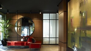 A modern interior with a red sofa, a large mirror, and a wooden floor. - SAY Hotel (Kifisia)