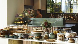 A buffet with various food items and a bar area with bottles. - SAY Hotel (Kifisia)