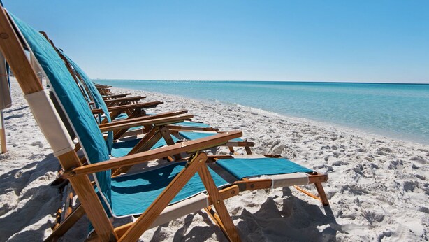 A row of wooden beach chairs with blue cushions on a sandy beach, facing a calm sea under a clear sky. - 2 Mins to the Gulf, Sleeps 10, Seagrove Beach + Free Attraction Tickets! (Santa Rosa Beach)