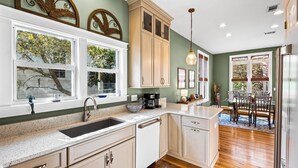 A kitchen with a large window, a sink, cabinets, and a dining area with chairs and a table. - 2 Mins to the Gulf, Sleeps 10, Seagrove Beach + Free Attraction Tickets! (Santa Rosa Beach)