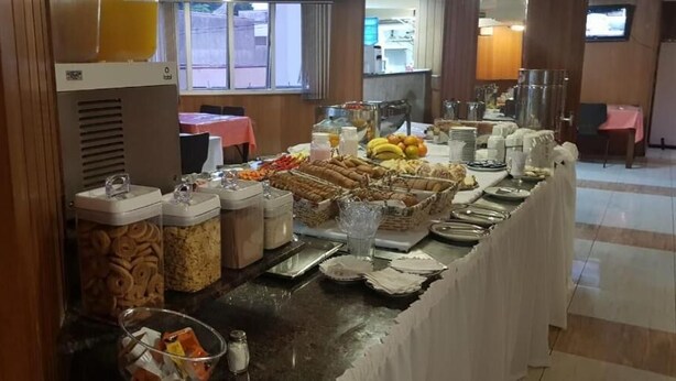 A buffet setup with various food items and containers. - Binder Hotel Mogi Guaçu (Mogi-Guaçu)