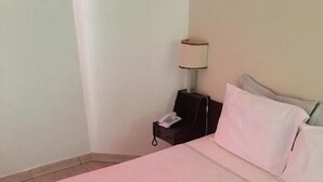 A neatly made bed with a pink bedspread and two folded white towels. - Binder Hotel Mogi Guaçu (Mogi-Guaçu)
