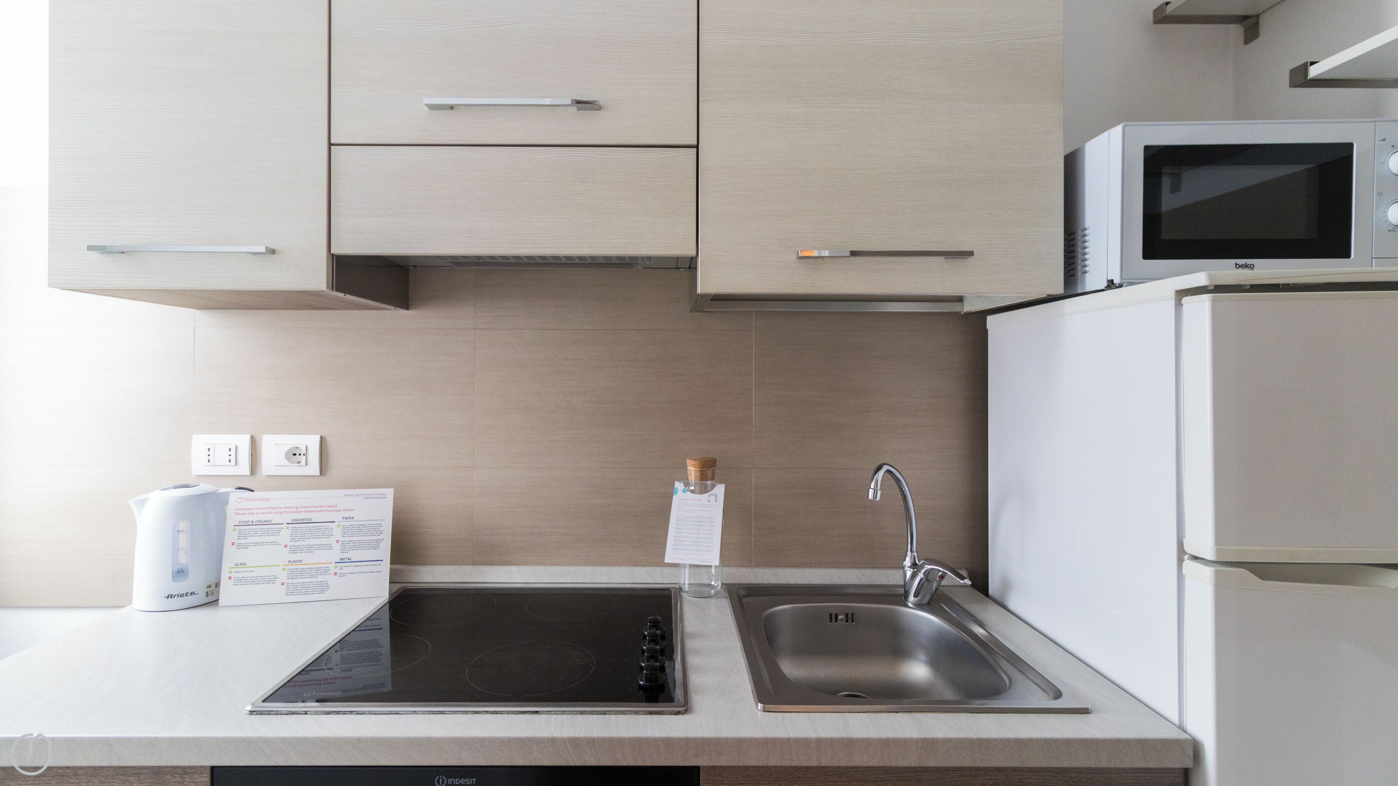 Una cocina moderna con estufa integrada, pileta y microondas.