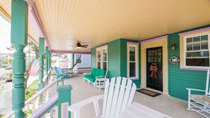 A porch with green walls, white railings, and a black door with a bow decoration. - One of a kind single family home, 6 bedrooms, sleeps 13 (Ocean City)