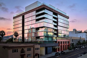 A multi-story building with a modern architectural design, featuring balconies and large windows.