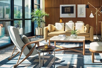 A poolside area with sun loungers, umbrellas, and a clear view of the pool. at The Hollywood Grande, Autograph Collection