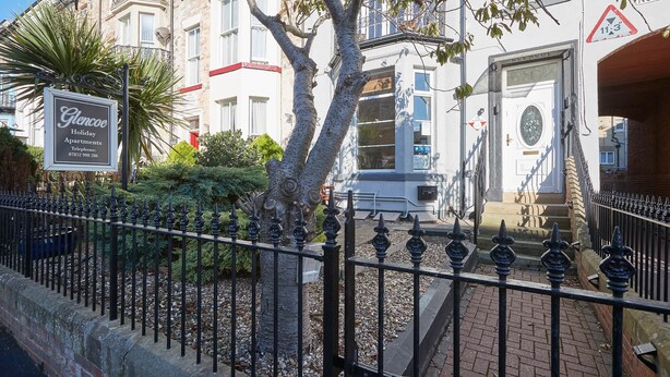 A gated entrance to a building with a sign for Glencoe Holiday Apartments. - Apartment 4 At Glencoe (Whitby)