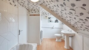 A modern bathroom with a freestanding bathtub, a toilet, and a sink. - Apartment 4 At Glencoe (Whitby)