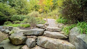 A garden with a stone pathway leading through a natural landscape. - Cozy Family Mountain Home in Seven Springs (CHAMPION)