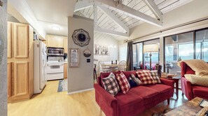 Relax in this open-plan living space with a kitchen, sofa, and armchair.