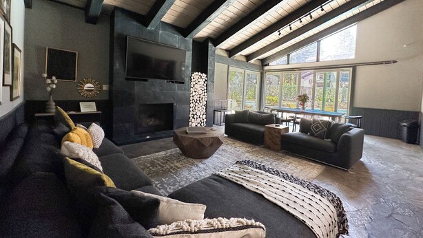 Amplia sala de estar con chimenea, un ventanal grande y un sofá moderno.