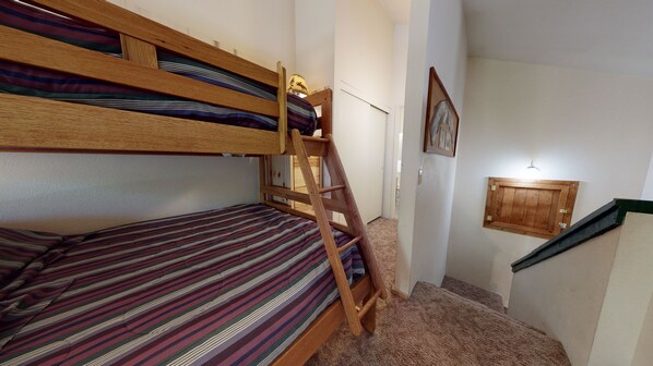A bunk bed with a wooden ladder, a striped mattress, and a small lamp on the wall. - Forest Setting, Walk to The Village & Gondola, Excellent Complex Amenities (Mammoth Lakes)
