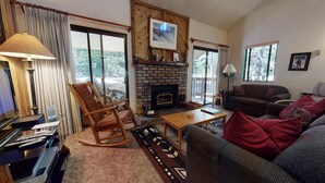 A cozy living room with a fireplace, a rocking chair, a sofa, and a coffee table. - Forest Quiet Setting, Walk to The Village. Pool On-site, Near the Lakes Basin (Mammoth Lakes)