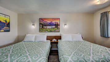 Une chambre d’hôtel avec deux lits, un tableau représentant un paysage de montagne et une affiche accrochée au mur.