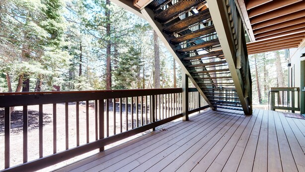 A wooden deck with a metal railing overlooking a forest. - Quiet Forest Setting. Near The Village & Lake Basin, Pool & Hot Tub On-site (Mammoth Lakes)