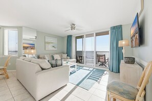 Un salón amplio con un sofá grande, una mesa de centro y un balcón con vistas.