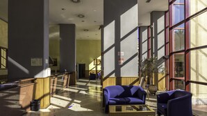 A lobby with a reception desk, a blue sofa, and a coffee table.