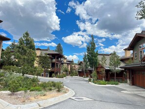 A residential area with multiple houses featuring wooden exteriors and large windows, surrounded by trees and a clear sky. - Modern Home, Great Mountain Views, Private Hot Tub, Gas Grill & Washer/Dryer (Mammoth Lakes)