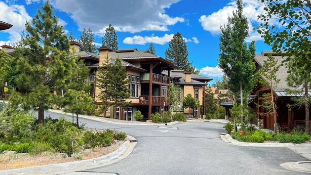 A modern resort with multiple-story buildings, a curved driveway, and surrounding greenery. - Modern Home, Great Mountain Views, Private Hot Tub, Gas Grill & Washer/Dryer (Mammoth Lakes)