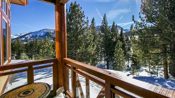 A wooden deck with a view of snow-covered mountains and pine trees. - Remodeled & Beautiful Home. Private Hot Tub & Gas Grill, Near Biking Trails (Mammoth Lakes)