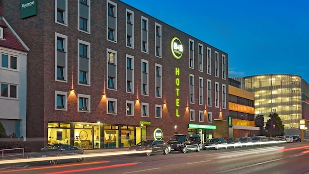 Un hôtel de type « bed and breakfast » avec une façade en briques, de nombreuses fenêtres et une entrée bien visible.