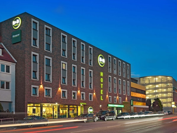 Un hôtel de type « bed and breakfast » avec une façade en briques, de nombreuses fenêtres et une entrée bien visible.
