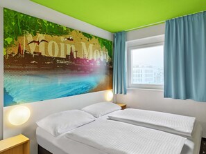 Une chambre d’hôtel avec un lit, deux tables de chevet, une fresque murale, une fenêtre avec des rideaux et un plafond vert.