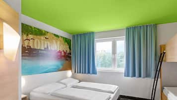 Een hotelkamer met een bed, een raam met gordijnen, een muur met een stadsgezicht mural en een ladder.