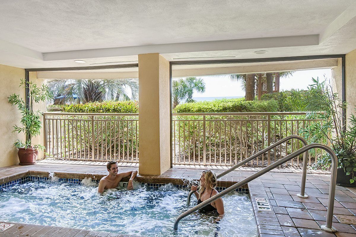 A hot tub area with a view of a landscaped garden and palm trees.
