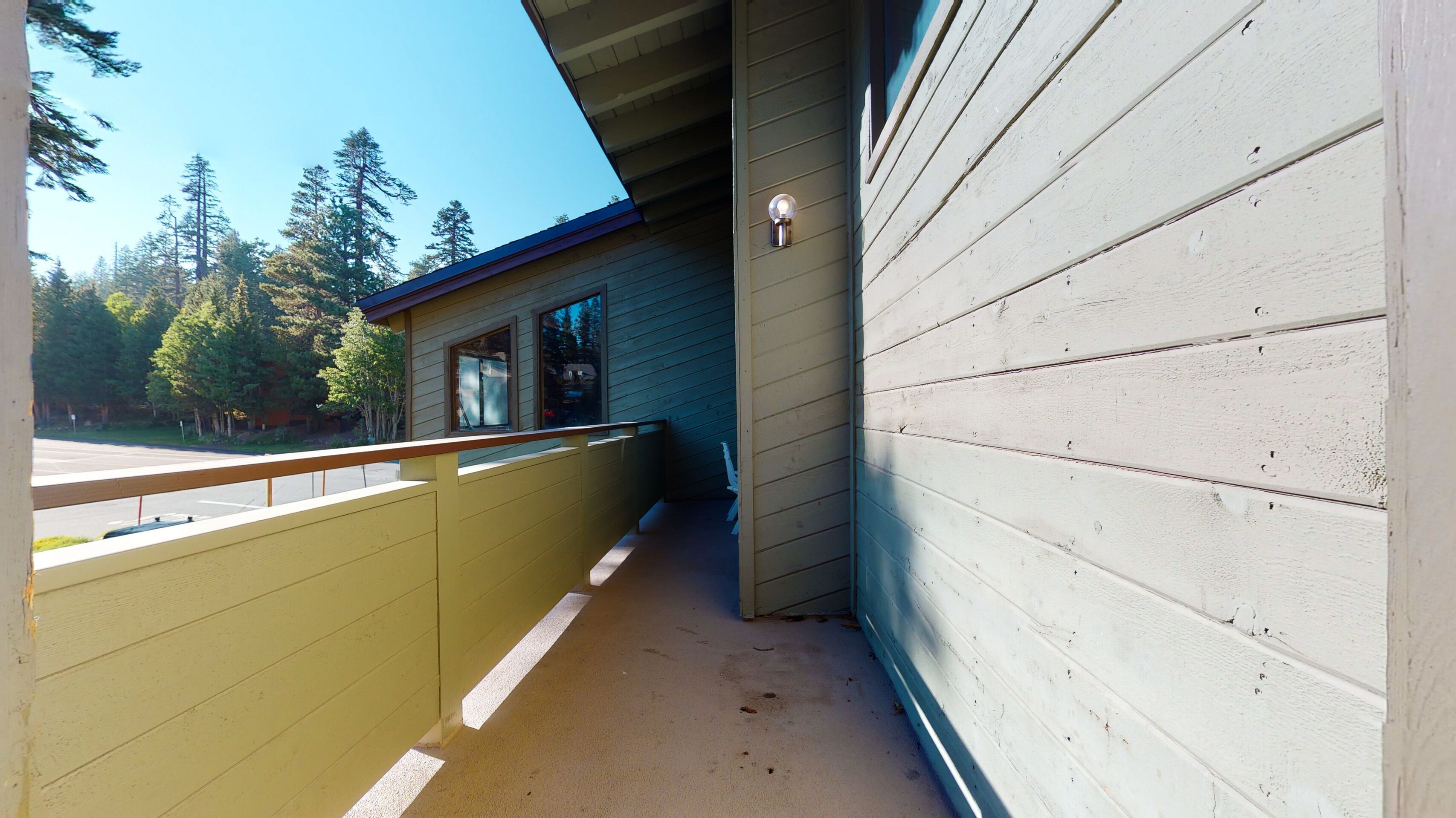 A wooden building with a balcony and a light fixture.