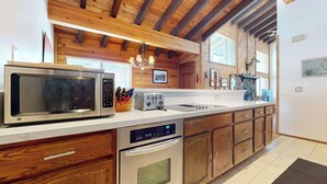 A modern kitchen with wooden cabinets, a stainless steel microwave, a toaster, and a dishwasher. - Rustic Home, Quiet Location. Near Bike Trails & Lakes Basin. Hot Tub On-site (Mammoth Lakes)