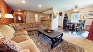 A living room with a sectional sofa, a coffee table, and a dining area with a table and chairs. - Pet-Friendly, Great Light! Gas Grill, Relaxing Location. Near Gorgeous Trails (Mammoth Lakes)