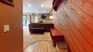 A cozy living room with a stone fireplace, a television, and a red bench. - Pet-Friendly, Great Light! Gas Grill, Relaxing Location. Near Gorgeous Trails (Mammoth Lakes)